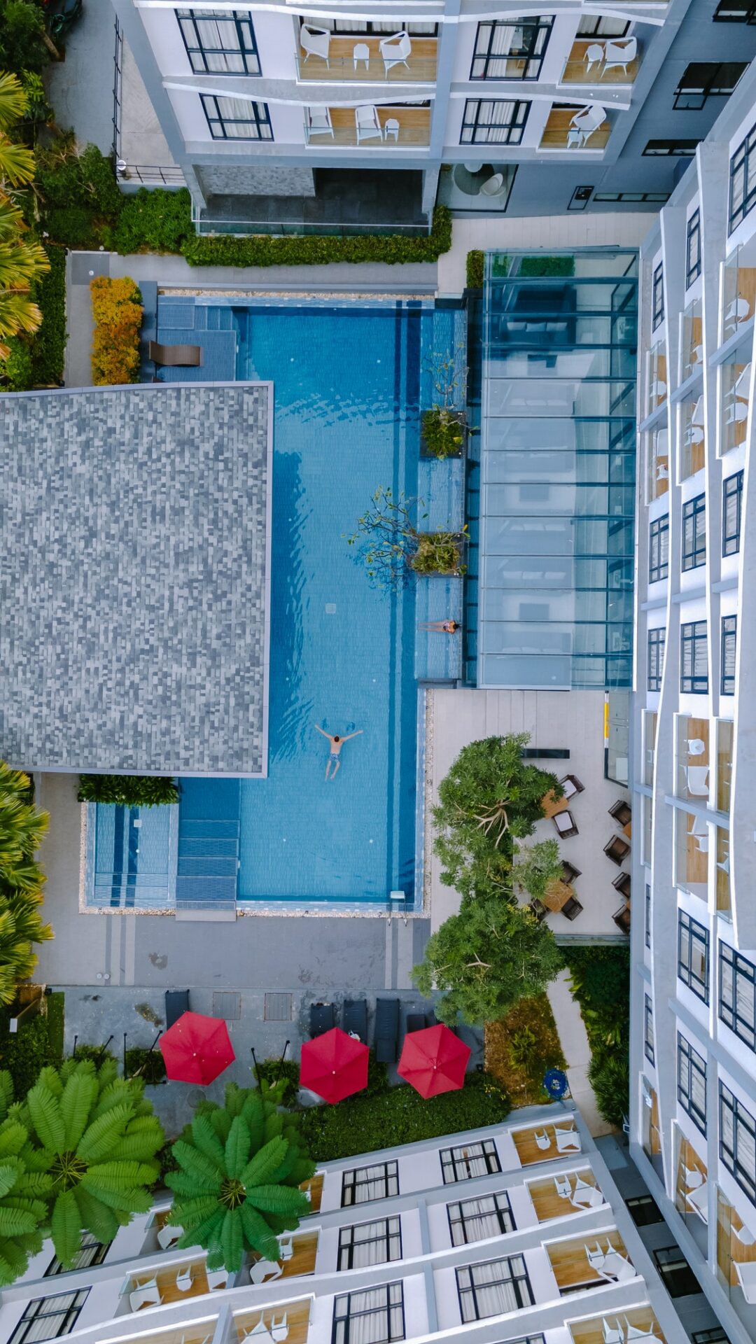 Drone view from above at swimming pool, couple men and women in swimming pool