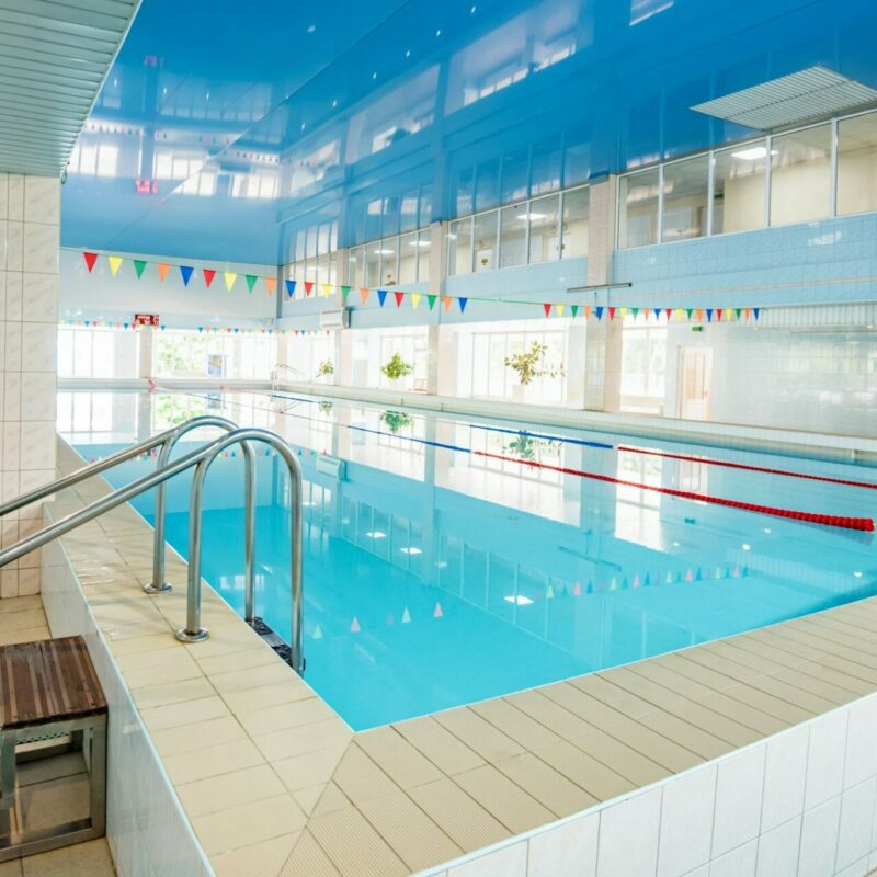 View of indoors swimming pool with metal ladder